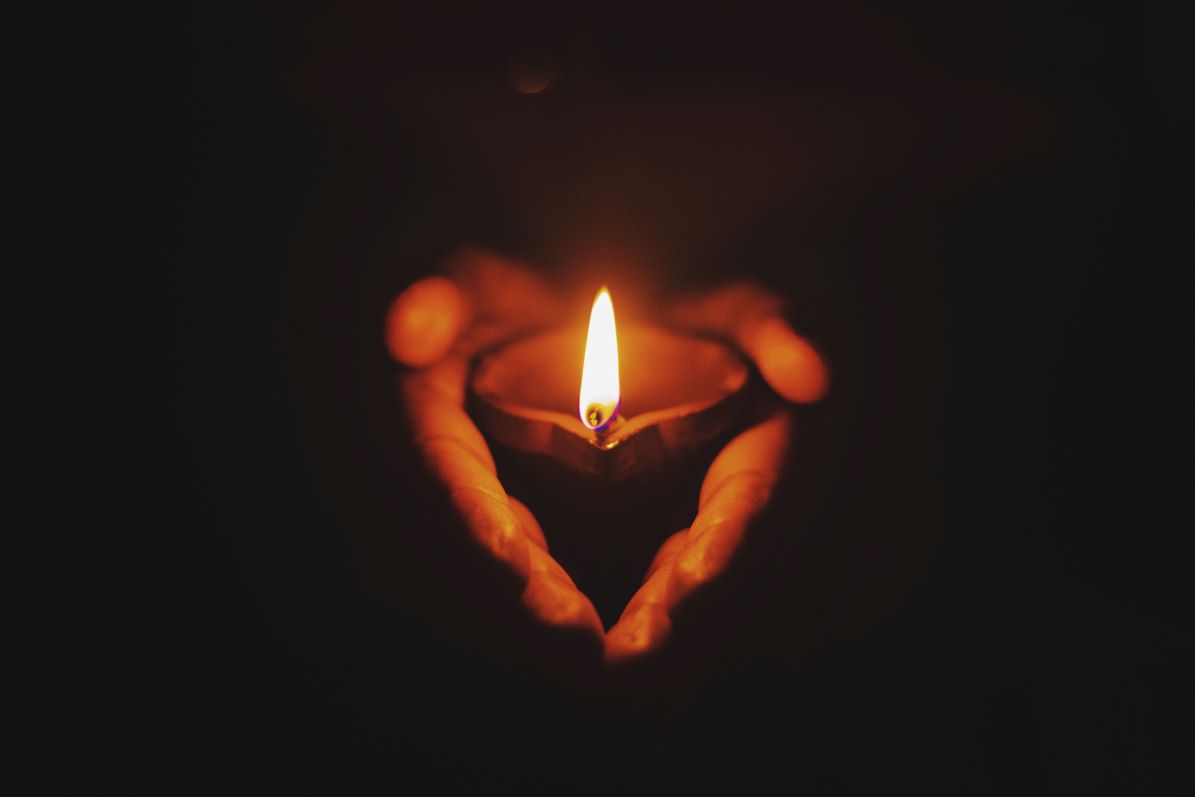 Person holding small lit candle