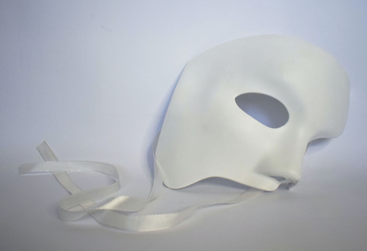 White half-mask laying on ground