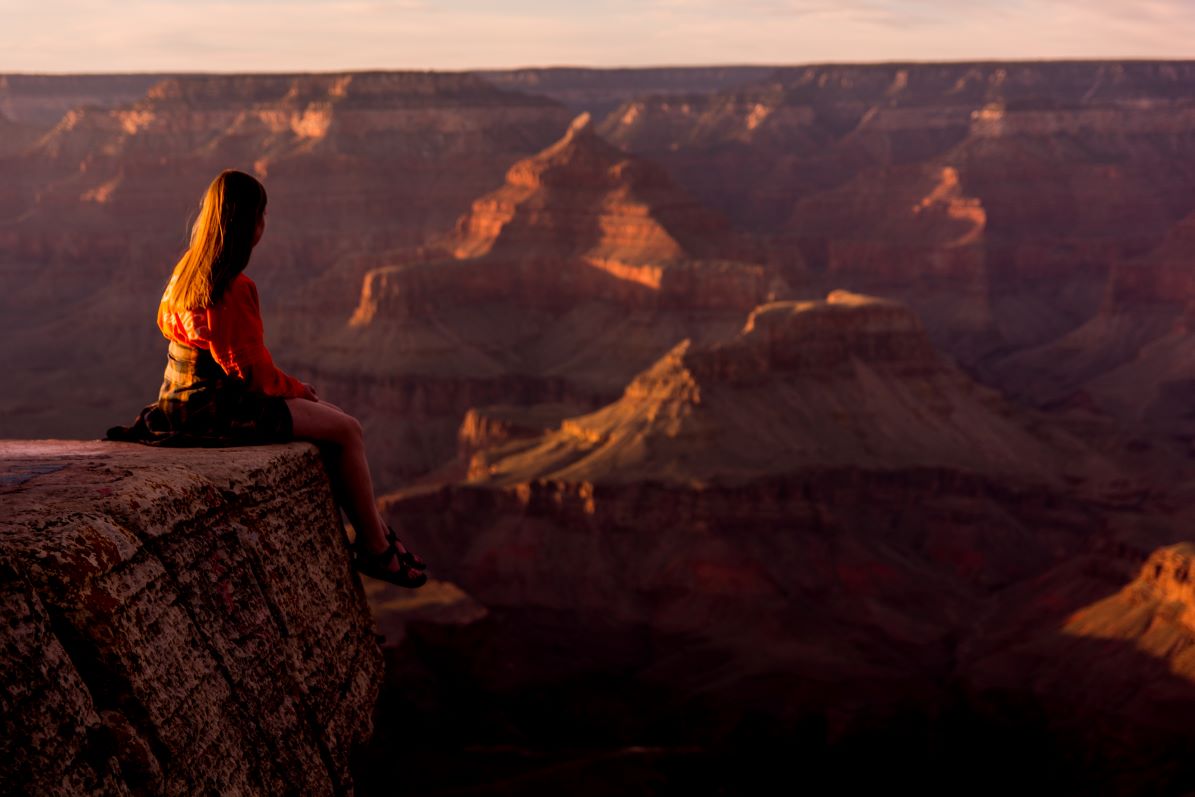 Woman sitting on mountaintop